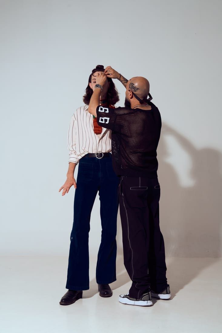 Sesiune de styling în studio: stilist aranjând părul unei cliente